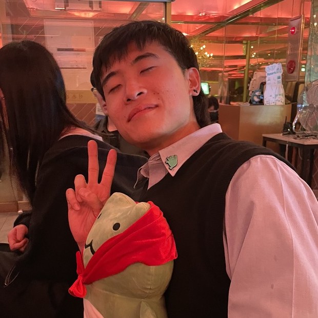 Yifang making a peace sign and holding a frog plush