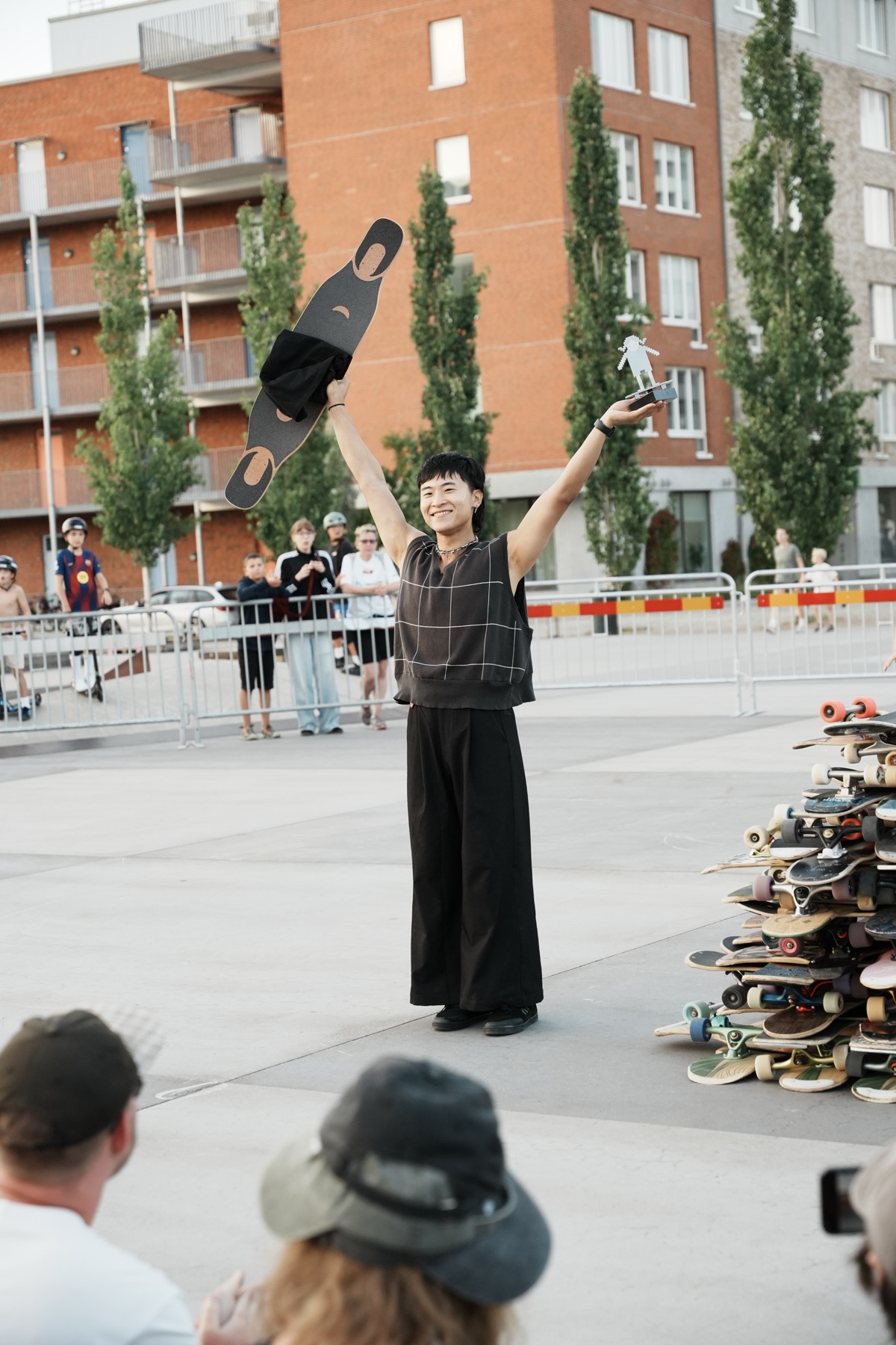 Yifang holding a longboard and a trophy overhead at the 2026 Skane Rolle competition in Malmo